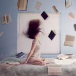 Woman on bed and books in the air